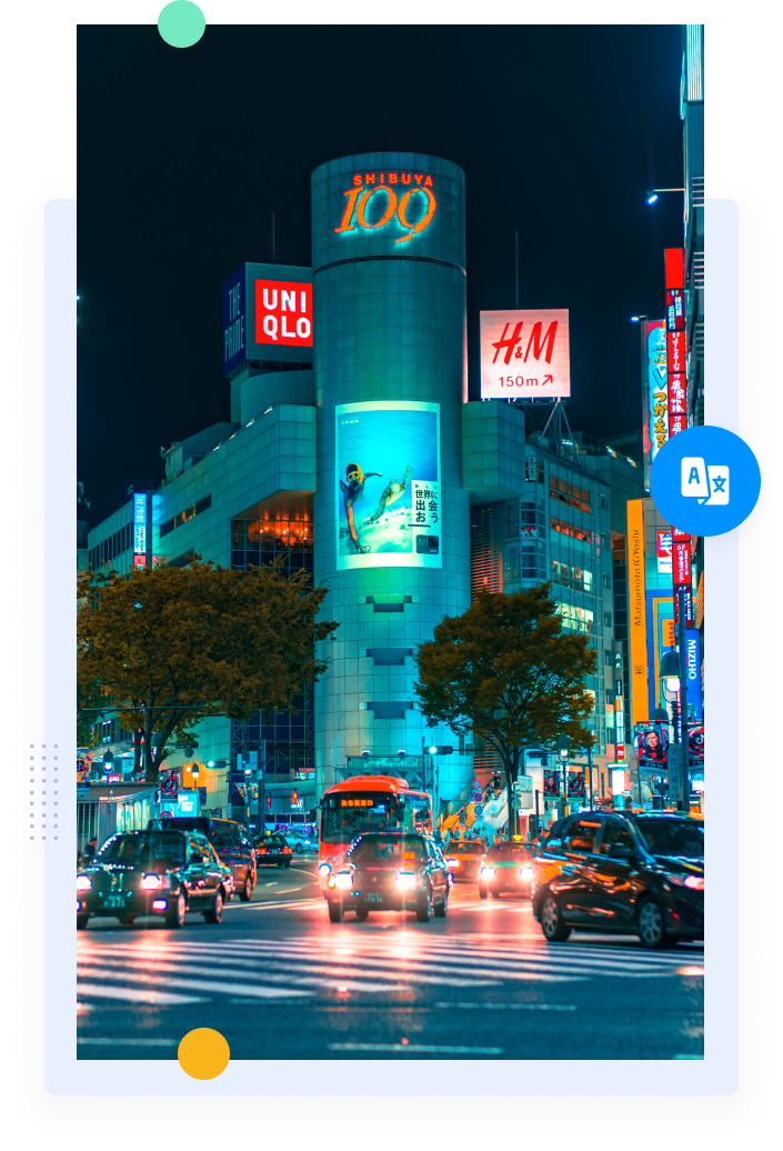 A busy street at night in Japan filled with bright lights, neon signs, pedestrians and vehicles outside buildings.